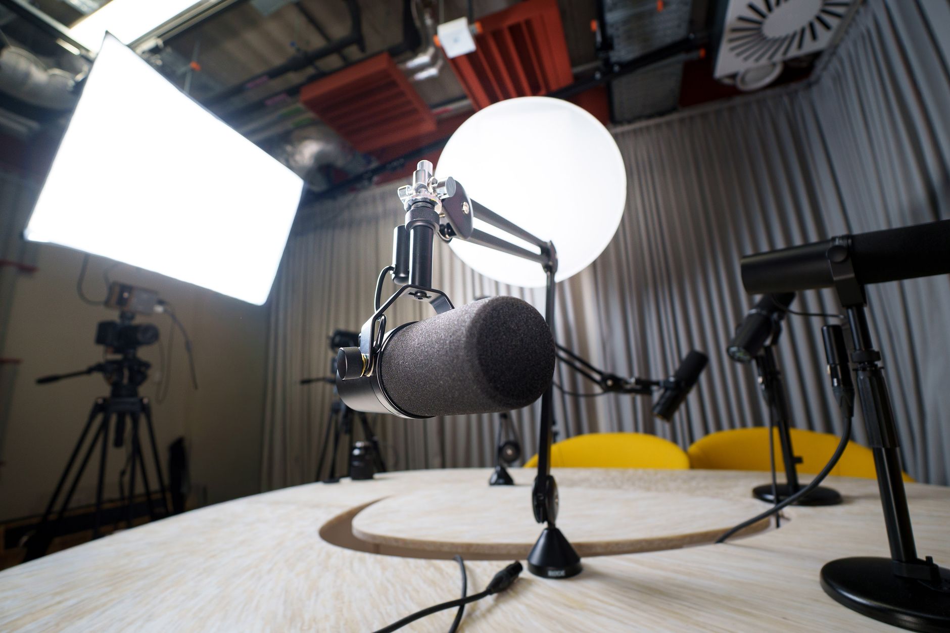 A studio broadcast microphone set up on a table for an interview.