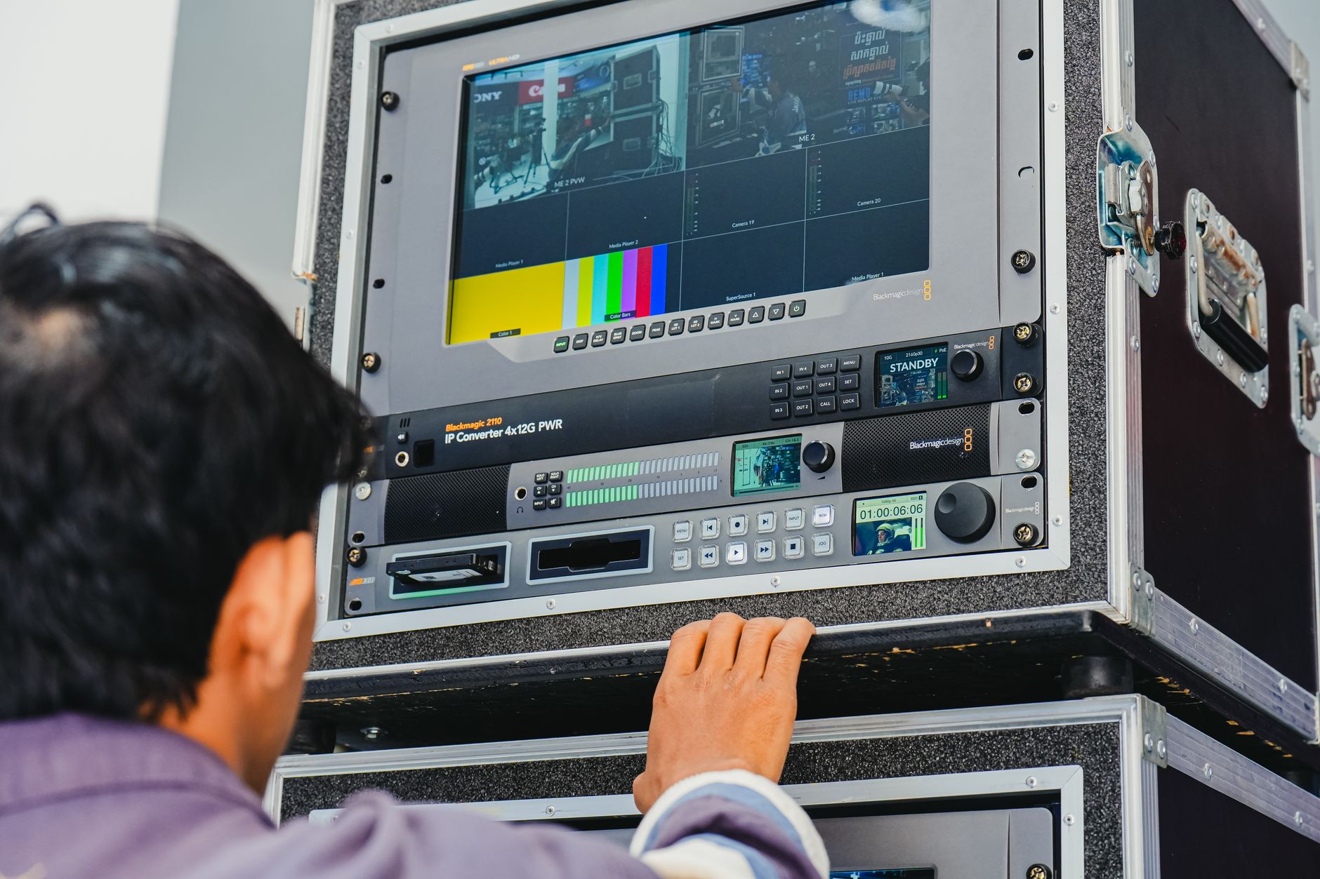 Video editing studio desk featuring multi-track timelines displayed across computer monitors.