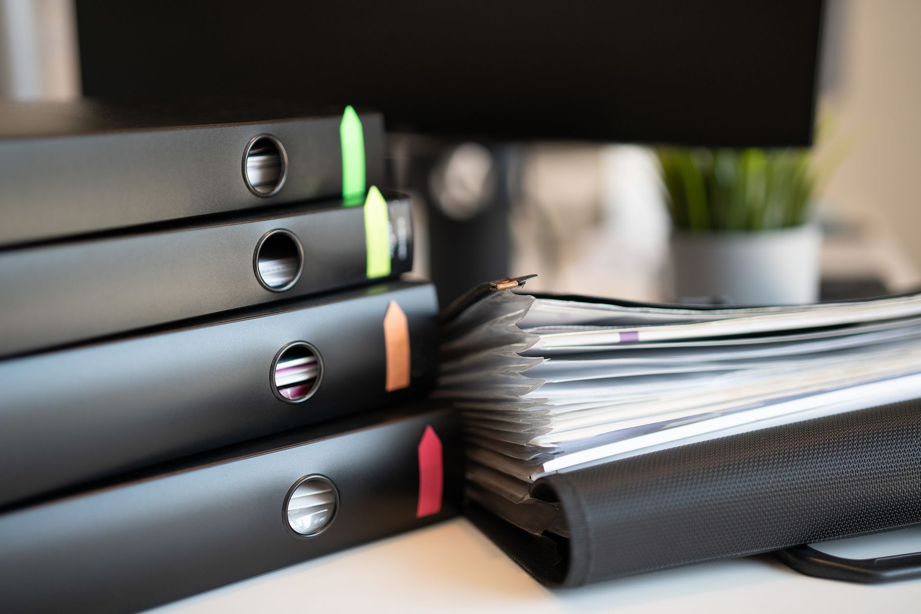 An office binder and manual open on a wooden desk.