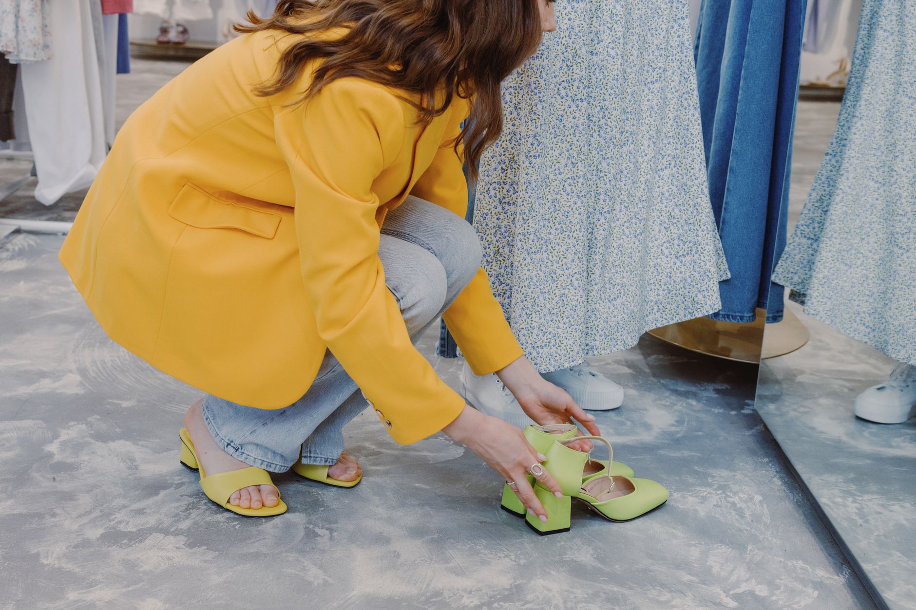 Shopper trying on shoes inside a physical retail store.