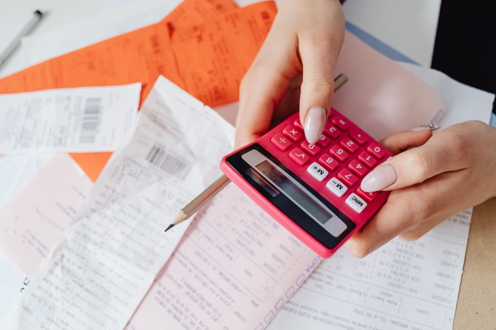 A close-up shot of a payment card resting near a calculated receipt on a desk.
